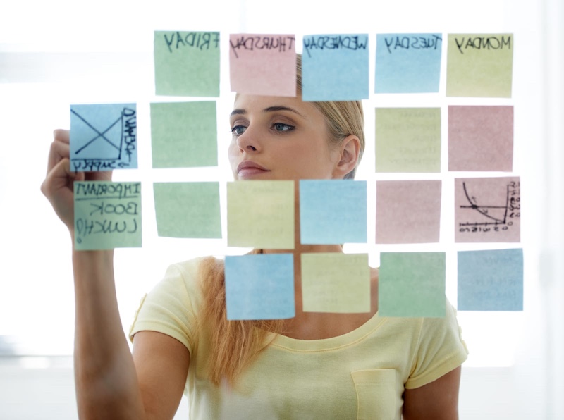 Woman making content calendar on sticky notes